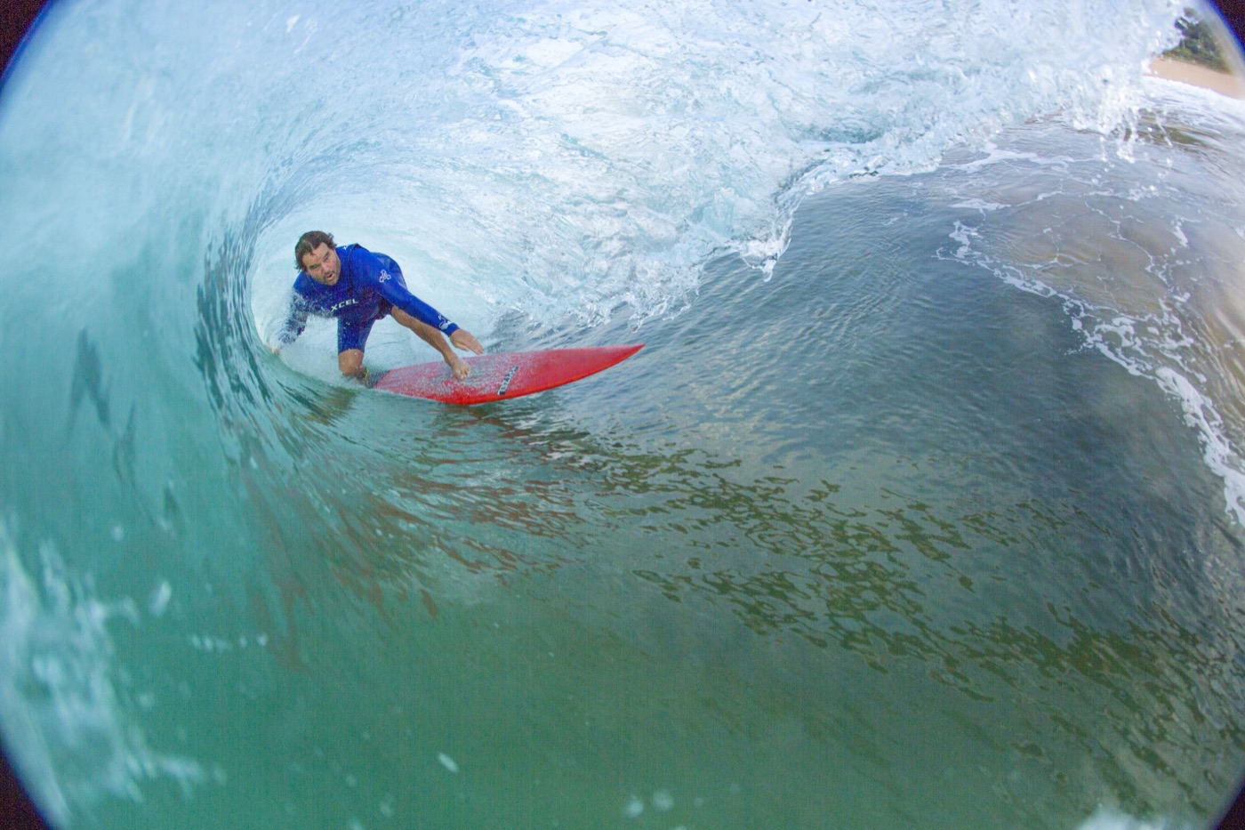 Inside the barrel behind a surfer