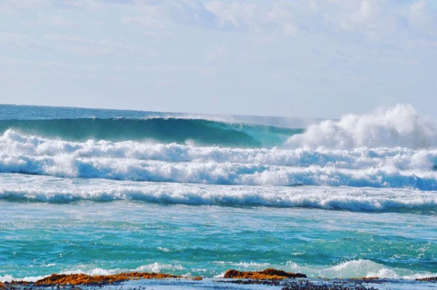 Big turquoise waves with offshore spray