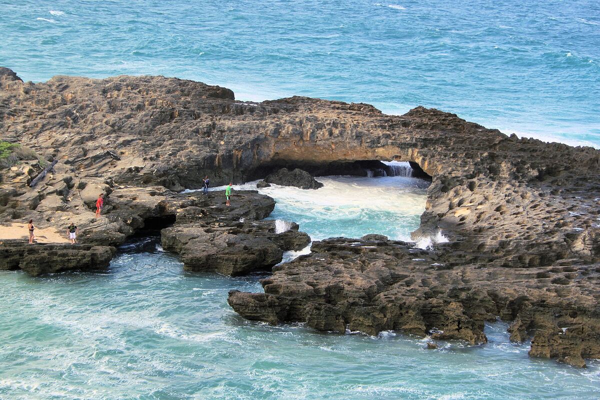 A rock arch on the reef at Pomene point with white water through it