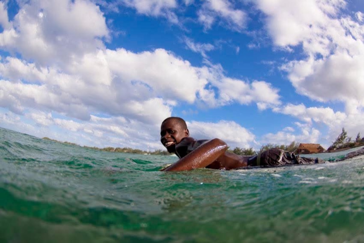 Local surfer paddling out under big clouds